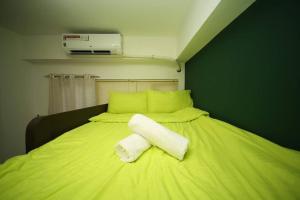 a green bed with a white towel on it at A2J Luxury 1BR Tagaytay Suite Near Skyranch, Malls in Tagaytay +14 photos