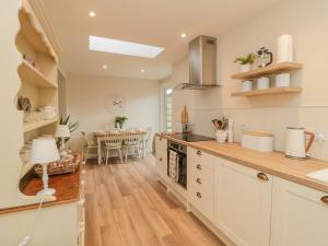 a kitchen with white cabinets and a dining room at 46 Castle Street in Berwick-Upon-Tweed