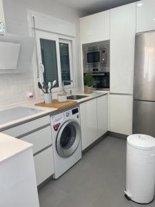 巴爾瓦特的住宿－Marismas Sol Barbate，白色的厨房配有洗衣机