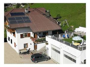 a car parked in front of a house with solar panels on the roof at Appartamenti Suttru in Badia