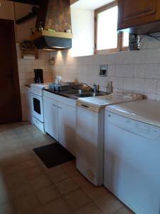 a kitchen with a sink and a washing machine at Gite Rural in Eygurande