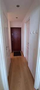 an empty hallway with a door and a wooden floor at Adelės Apartamentai Panevėžyje in Panevėžys