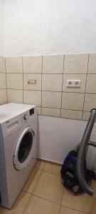 a washing machine in a room with a vacuum at Adelės Apartamentai Panevėžyje in Panevėžys