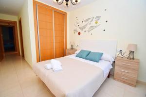 a bedroom with a large white bed with blue pillows at Expoholidays-Brisas Almerimar in Almerimar