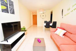a living room with a couch and a flat screen tv at Expoholidays-Brisas Almerimar in Almerimar