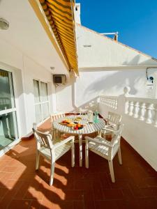 een patio met een tafel en stoelen op een balkon bij Apartamento con piscina en Las Rosas de Capistrano in Nerja