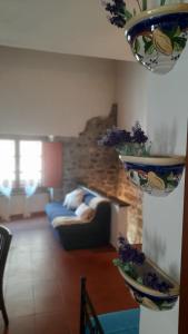 ein Wohnzimmer mit einem Sofa und zwei Vasen an der Wand in der Unterkunft La Casetta in Fivizzano