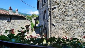 ein altes Steingebäude mit Blumen davor in der Unterkunft La Casetta in Fivizzano