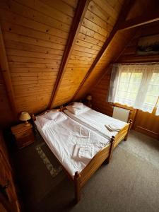 a bedroom with a bed in a wooden cabin at Chata Sosnówka Residence in Sosnówka