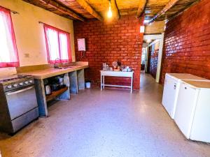 a large kitchen with a brick wall at Hotel Punta Ballenas in Máncora