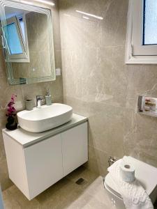 bagno con lavandino, specchio e servizi igienici di City Center Hub a Xánthi