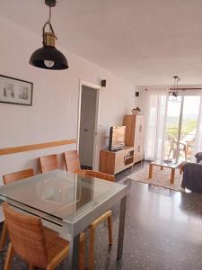 een woonkamer met een glazen tafel en stoelen bij Precioso aptmento en Gilet a pies de la Calderona in Gilet