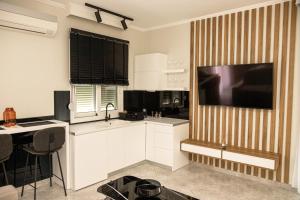 een keuken met een grote flatscreen-tv aan de muur bij City Center Hub in Xanthi