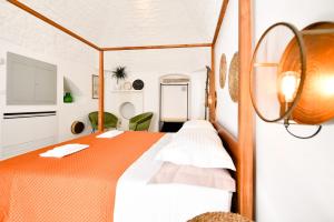 een slaapkamer met een bed met een oranje deken bij Corte Giotto Exclusive House in Carovigno