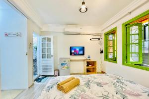 a bedroom with a bed and a tv at Vitamin Home Hoàn Kiếm 35 in Hanoi
