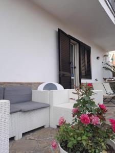 un patio con sofá, flores y ventana en B&B Quattro Lune, en Prignano Cilento