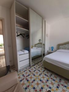 une chambre avec deux lits et un miroir dans l'établissement Villa Angela, à Ischia