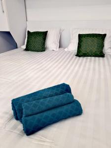a blue blanket on a bed with two pillows at Christopher Apartment in Oradea