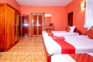 a bedroom with two beds and orange walls at Blossoming Romduol Boutique in Siem Reap