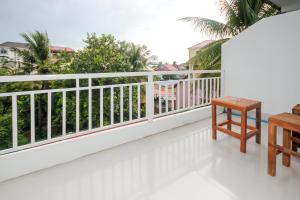 a balcony with white railing and a wooden table at Blossoming Romduol Boutique in Siem Reap