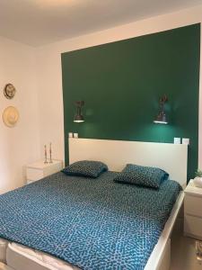 een slaapkamer met een blauw bed met 2 kussens bij Apartment with views of sea and mountains in Taurito