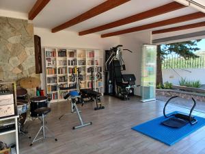 Un gimnasio con cintas de correr y equipos de ejercicio en una habitación. en Villa Martina, en Isquia