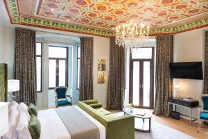 ein Schlafzimmer mit einem großen Bett und einem Kronleuchter in der Unterkunft Itza Hotel Boutique Internacional in Cuenca