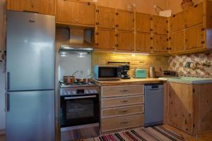eine Küche mit einem Kühlschrank aus Edelstahl und Holzschränken in der Unterkunft villa archontiko ASKYFOU SFAKIA in Karés