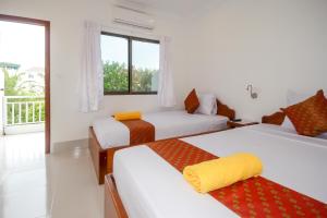 a bedroom with two beds and a balcony at Blossoming Romduol Boutique in Siem Reap
