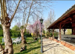 una luz de la calle en un parque con una mesa de picnic y árboles en Chambres d'hôtes Les Vignes, en Montcet