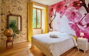 een slaapkamer met een bed met roze bloemen aan de muur bij La Maison Magique in Saint-Chamassy