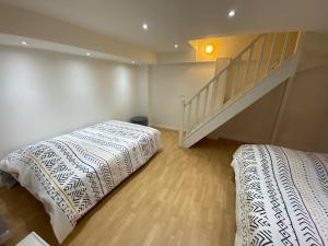 ein Schlafzimmer mit einem Bett und einer Treppe in der Unterkunft Duplex Cosy proche Paris(5mn)sans commission en + in Alfortville