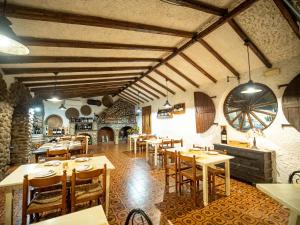 a restaurant with wooden tables and chairs in a room at Albergo Ristorante Locanda Rosella in Giba