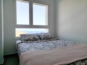 a bed in a room with a window at Las Palmas Golf & Beach in Las Palmas de Gran Canaria +9 photos