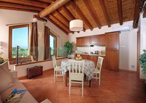 Residence Borgo Mondragon في لازيسي: مطبخ وغرفة طعام مع طاولة وكراسي
