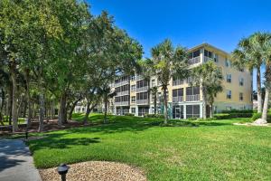 a large apartment building with palm trees in a park at Waterfront Condo with Boat Dock, Gym and Pool! in Palm Coast