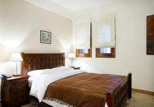 a bedroom with a large bed and two windows at Xenonas Iresioni in Arachova