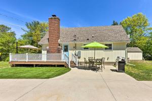 una casa con terrazza con tavolo e ombrellone di Breezy Silver Lake Getaway Fishing Dock, Grill! a Mears