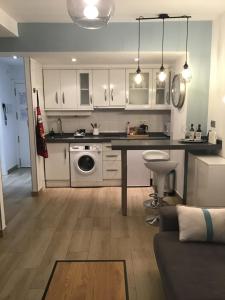 a kitchen with white cabinets and a table at Fantastico Apartamento Suite en centro de Granada in Granada +29 photos