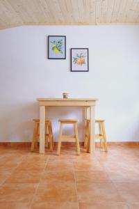 a wooden table and two stools in a room at Casinha da Eira in Góis