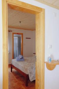 a bedroom with a bed with a wooden frame at Casinha da Eira in Góis