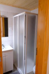 a white shower in a bathroom with a sink at Casinha da Eira in Góis