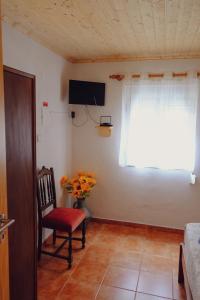 a living room with a chair and a window at Casinha da Eira in Góis