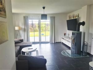 a living room with a couch and a tv at Exklusives Ferienhaus "An der Nordsee" in Großheide