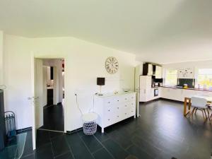 a kitchen with white cabinets and a table and chairs at Exklusives Ferienhaus "An der Nordsee" in Großheide