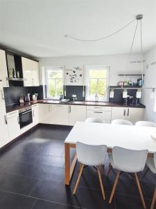 a kitchen with a white table and white chairs at Exklusives Ferienhaus "An der Nordsee" in Großheide