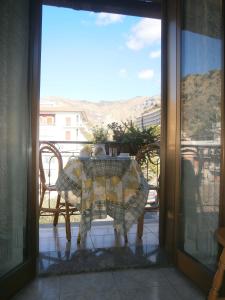 un tavolo e sedie su un balcone con vista di Hotel Pensione Cundari a Taormina