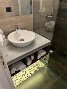 a bathroom with a sink and a shower at Kanes Boutique Hotel in Sarandë