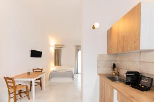 a kitchen with a table and a bed in a room at Muses Apartments in Agia Anna