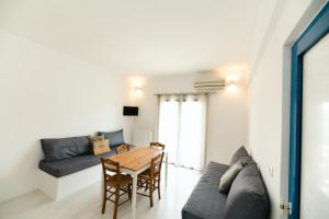 a living room with a table and a couch at Muses Apartments in Agia Anna